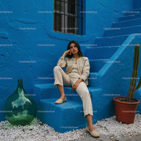 Elegant Woman in Traditional Attire Against a Vibrant Blue Wall