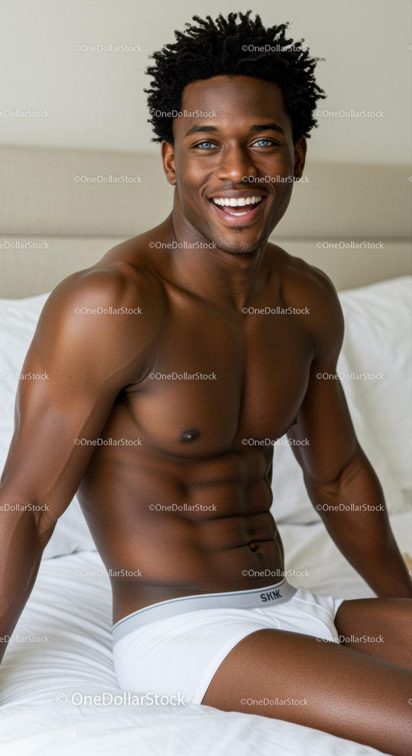 Smiling fit man relaxing on white bed at home
