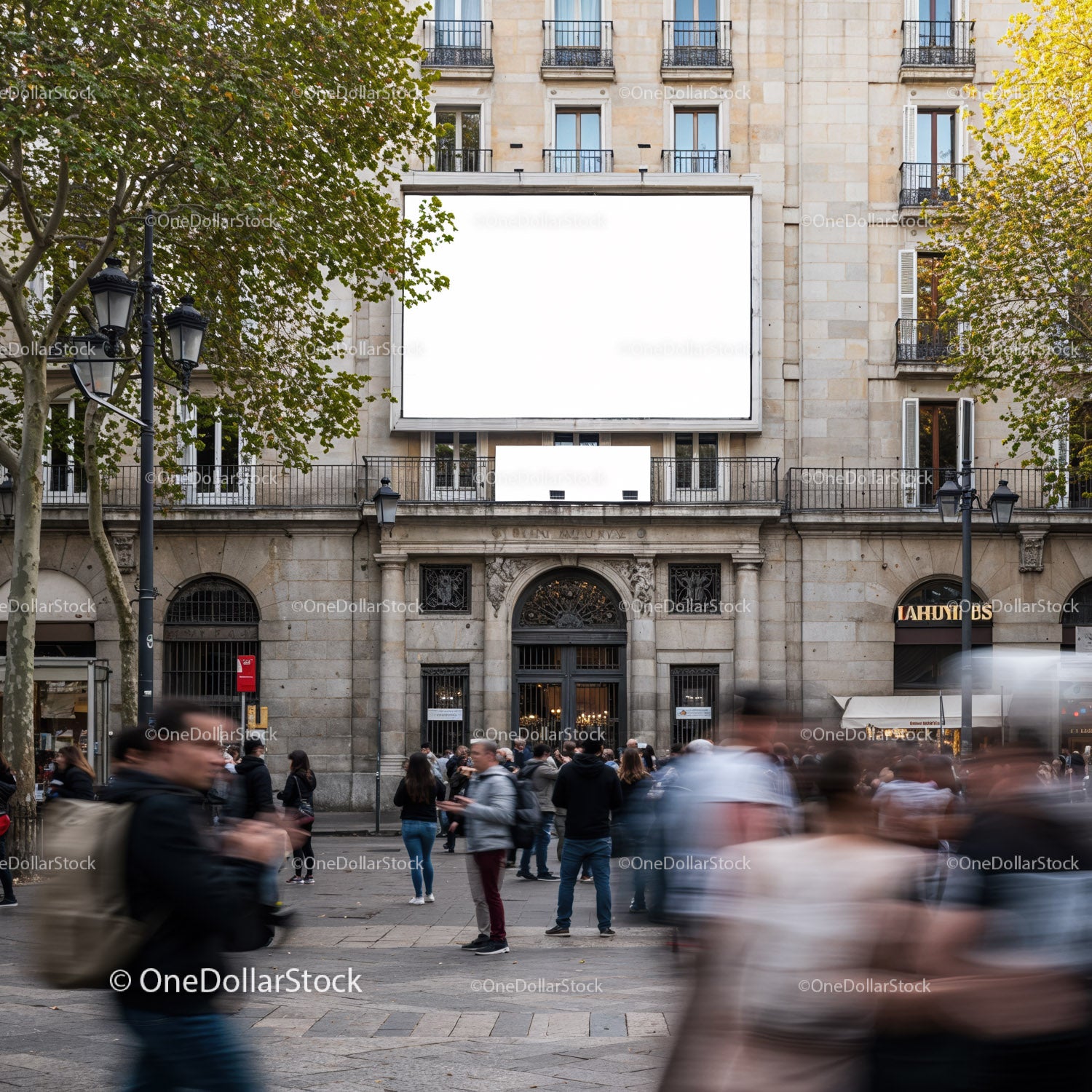 Busy urban square with blank billboard on historic building