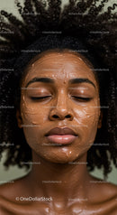 Woman with Curly Hair Applying Clay Facial Mask for Skincare