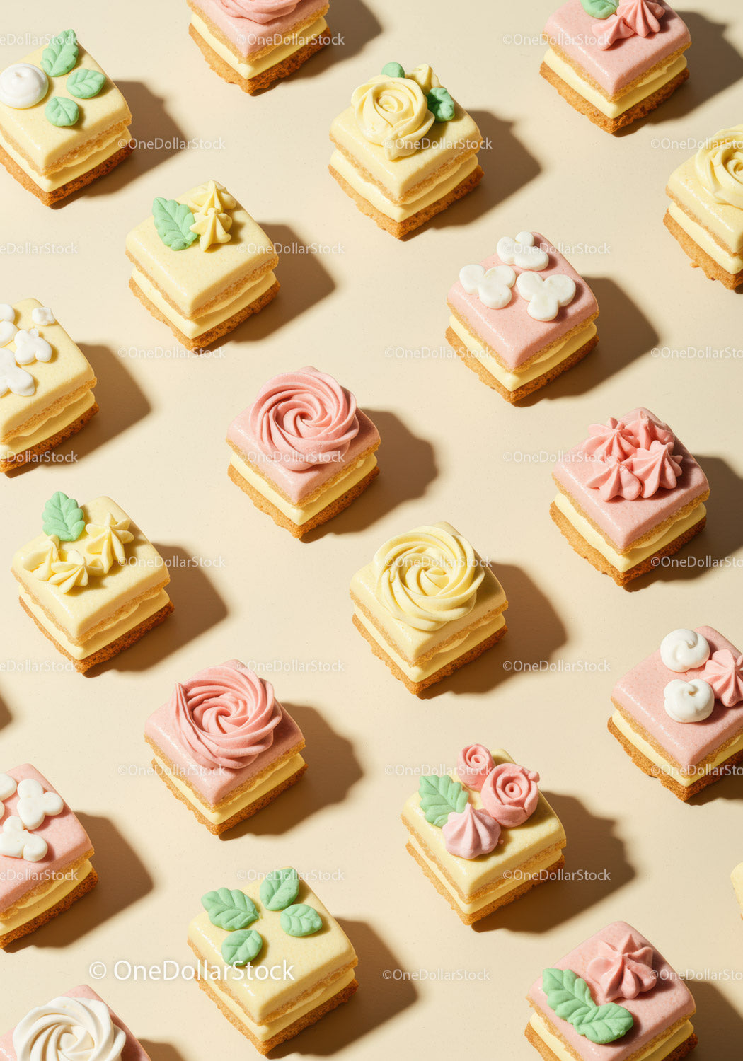 Delikatne kwadratowe petit fours z pastelową dekoracją kwiatową