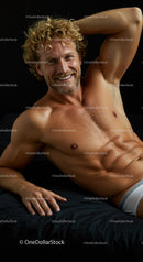Relaxed young man lying on bed smiling confidently