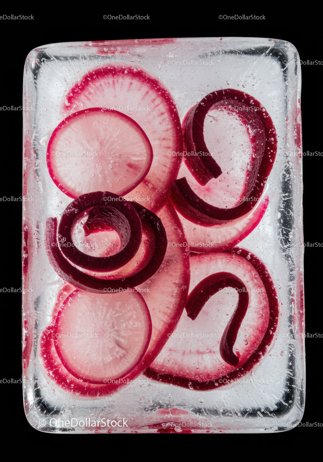 Red radish slices frozen inside a clear ice cube