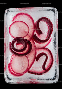 Red radish slices frozen inside a clear ice cube