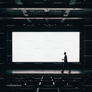 Person walking in empty cinema with bright screen