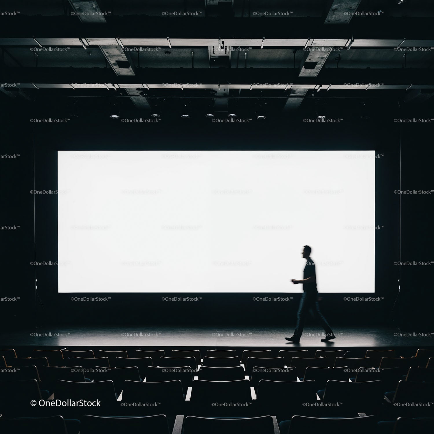 Person walking in empty cinema with bright screen