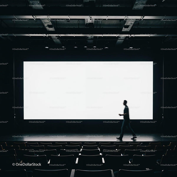 Person walking in empty cinema with bright screen JPG Mockup Image