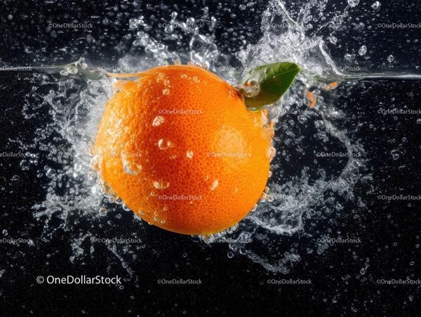 Juicy Orange Splashing into Water with Fresh Green Leaf