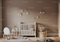 Cozy Baby Nursery with Cloud Wall Hangings and Teddy Bear Cushion