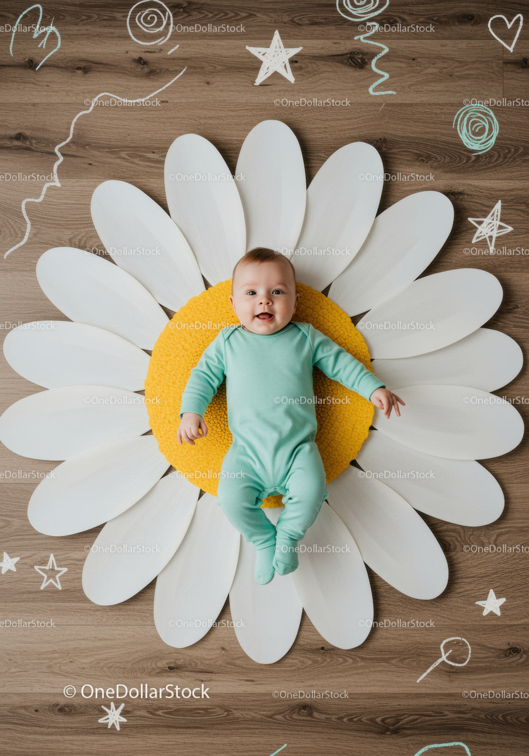 Happy baby lying on large decorative daisy flower