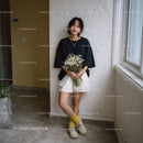 Young Woman Holding Daisy Bouquet in Bright Indoor Setting