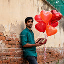 Man holding heart balloons and chocolate gift box