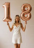 Young woman celebrating eighteenth birthday with balloons