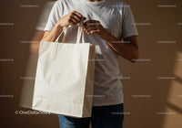 Man holding blank white reusable shopping bag indoors