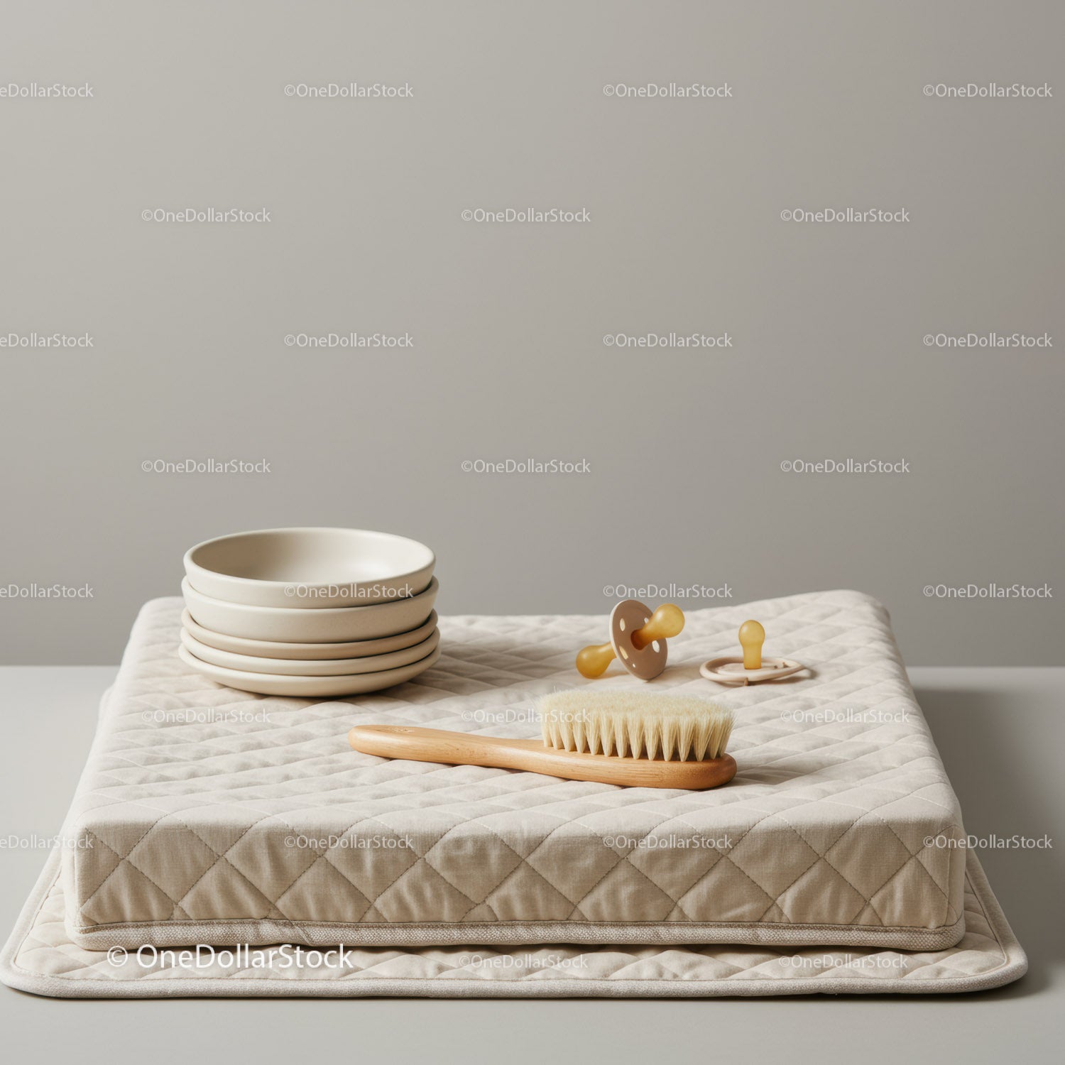 Minimalist baby care items on quilted beige cushion