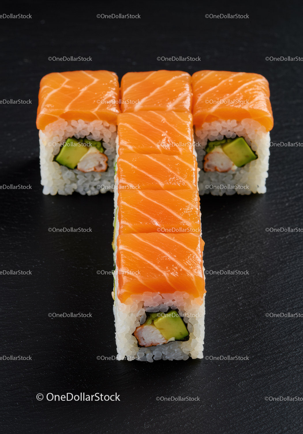 Świeże rolki sushi z łososiem i awokado na ciemnym tle
