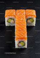 Fresh salmon sushi rolls with avocado on dark background