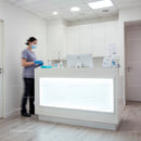Healthcare receptionist wearing mask at modern clinic desk