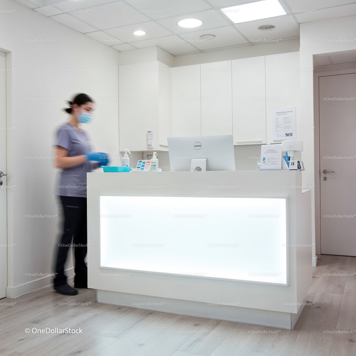 Healthcare receptionist wearing mask at modern clinic desk