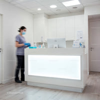 Healthcare receptionist wearing mask at modern clinic desk
