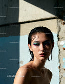 Wet young woman with colorful eye makeup in soft light