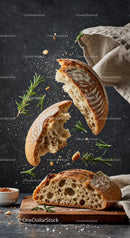 Rustic sourdough bread breaking with fresh rosemary sprigs