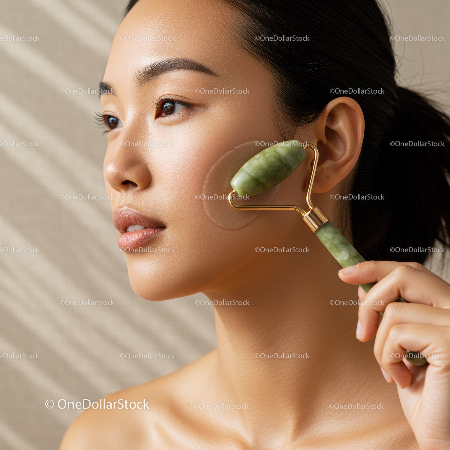 Close-up of Woman Using Jade Roller for Facial Massage with Green Jade