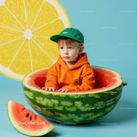 Young boy sitting inside a hollow watermelon with bright backdrop