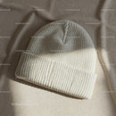 Cozy ribbed knit beanie hat on soft fabric background