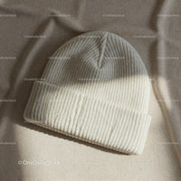 Cozy ribbed knit beanie hat on soft fabric background