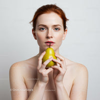 Redhead Woman Holding Pear in Minimalist Portrait