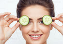 Smiling Woman with Cucumber Slices Over Eyes in Skincare and Beauty
