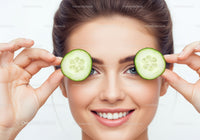 Smiling Woman with Cucumber Slices Over Eyes in Skincare and Beauty
