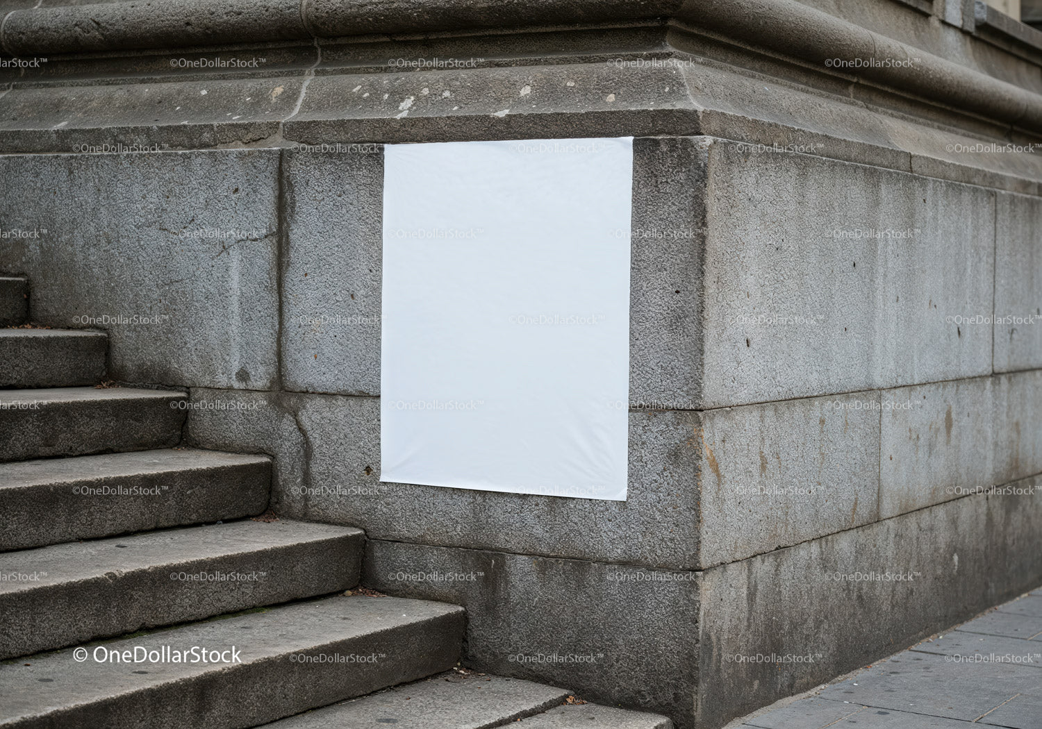 Blank white poster on urban stone wall near stairs