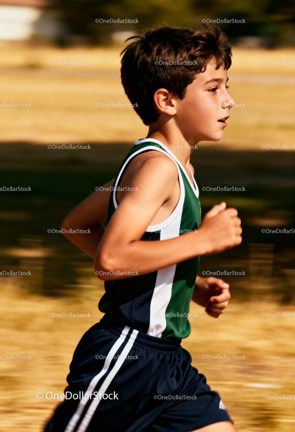 Focused boy running outdoors in athletic wear