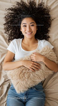 Smiling woman lying on bed with fluffy pillow