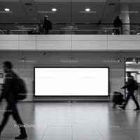 Busy urban commuters passing blank billboard in transit hub