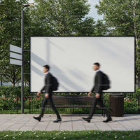 Two businessmen walking past large blank billboard outdoors