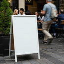 Blank White Sidewalk Sign Outside Busy Café