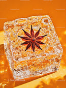 Star Anise Embedded in Clear Ice Cube on Orange Background