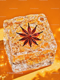 Star Anise Embedded in Clear Ice Cube on Orange Background