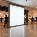 Bright Blank Advertisement Panel in Busy Shopping Mall