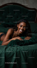 Smiling woman relaxing on dark green velvet bed