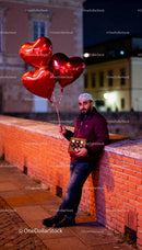Man with Heart Balloons and Valentine's Chocolates at Night