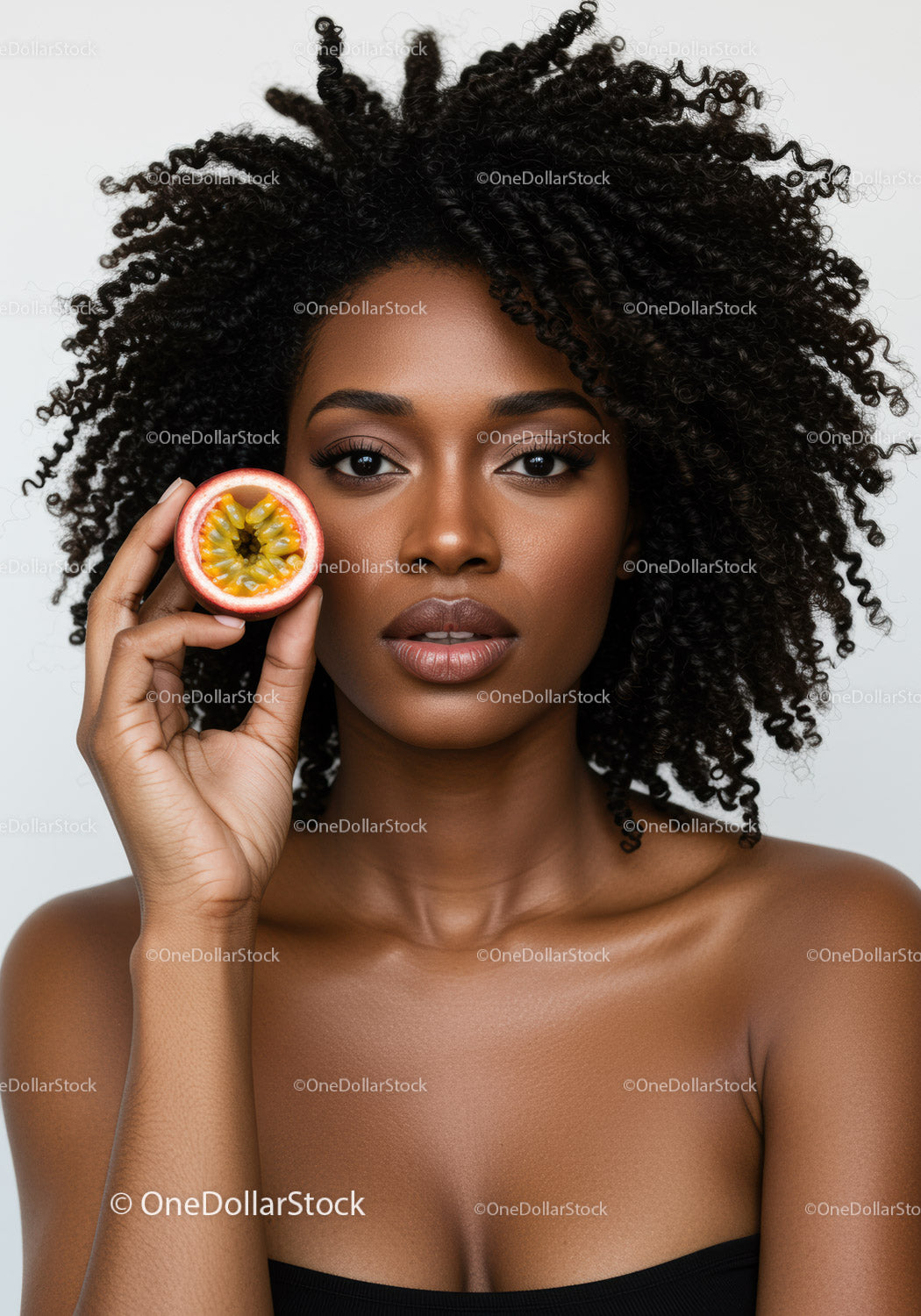 Beautiful African American Woman with Curly Hair Holding Passion Fruit