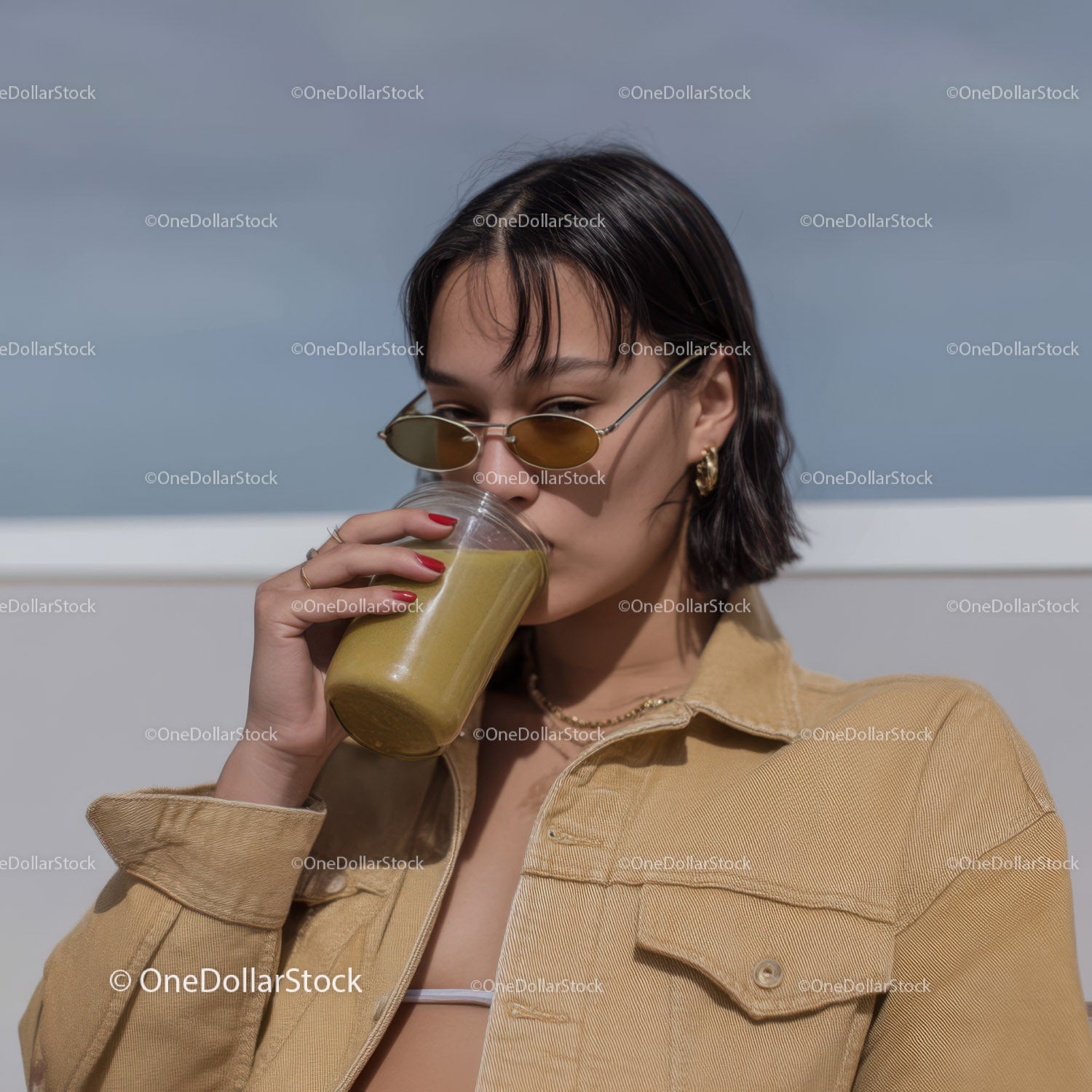 Young Woman Drinking Smoothie Wearing Sunglasses and Summer Clothing