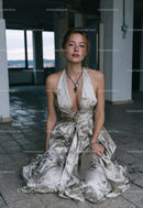 Elegant Young Woman in Floral Dress Sitting on Floor in Modern Interior
