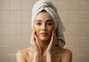 Young Woman Applying Facial Mask in Spa for Skin Rejuvenation