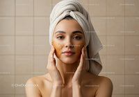 Young Woman Applying Facial Mask in Spa for Skin Rejuvenation