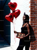 Confident woman with heart balloons and chocolates